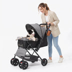 Woman walking a small dog in a black foldable 4-wheel pet stroller with a reversible handle