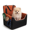 Small dog sitting in a quilted pet car seat with side pocket and travel accessories