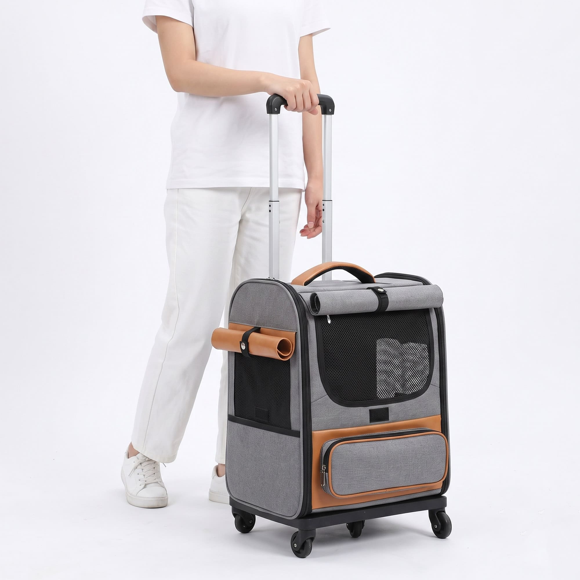 Person pulling gray wheeled pet carrier with telescoping luggage handle