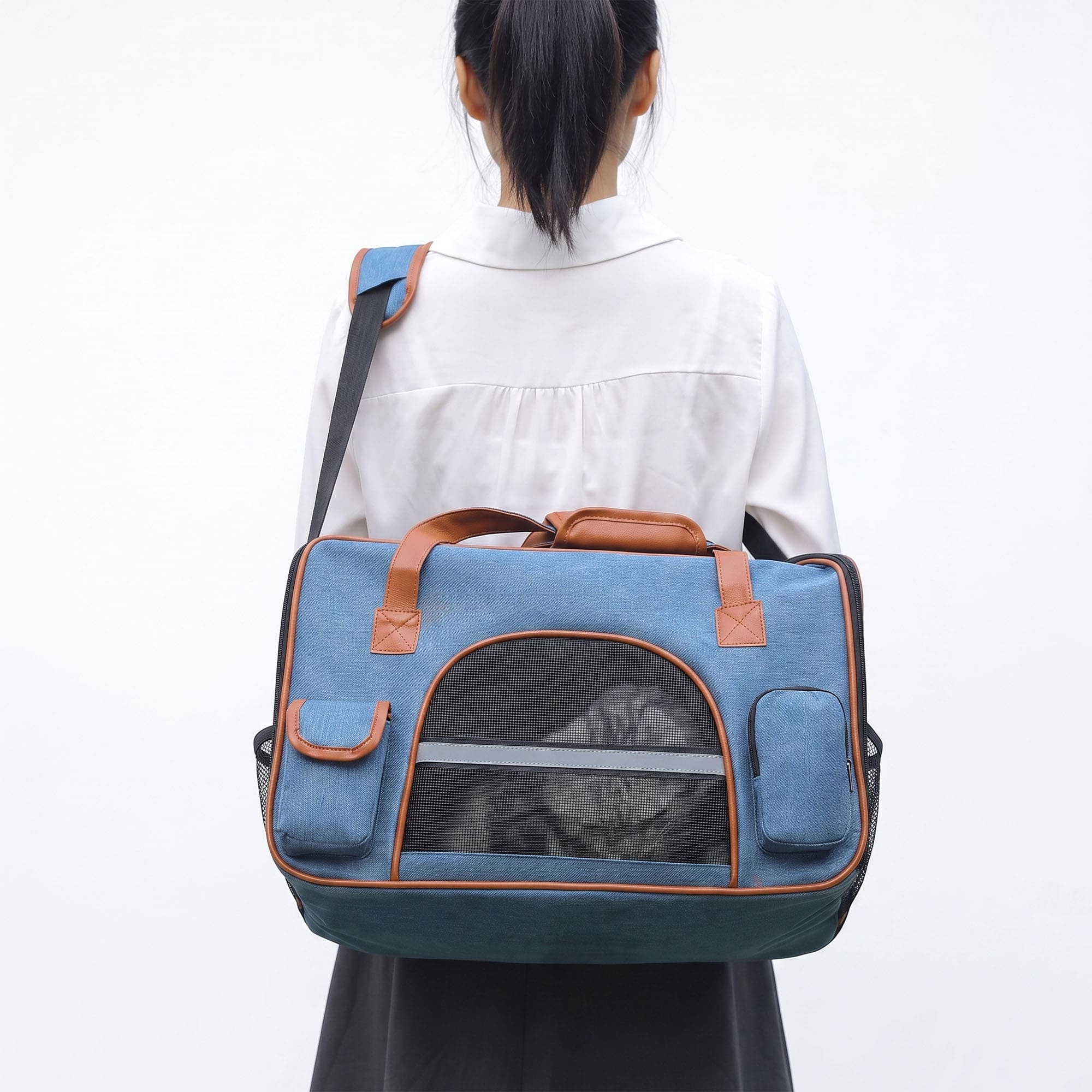 Person carrying blue pet carrier tote with cat inside breathable mesh window